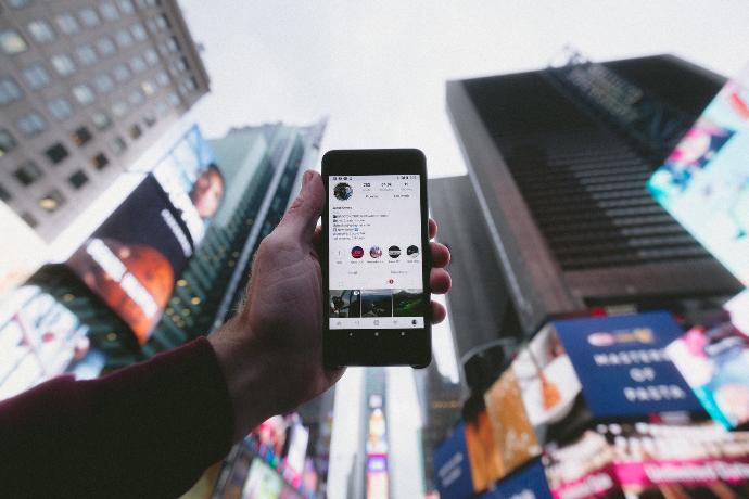 high angle photo of person holding turned on smartphone with tall buildings background